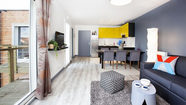 Un appartement moderne doté d’un balcon, d’un coin repas et d’un salon.
