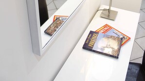 A hotel room with a white desk, a mirror, a lamp, and two magazines. - NEW SWEET FLORENCE (at T2 Belfiore) (Firenze)