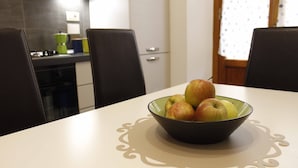 A dining table with a bowl of apples and a decorative table runner. - NEW SWEET FLORENCE (at T2 Belfiore) (Firenze)
