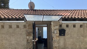 Un edificio rústico con tejado de tejas, antena parabólica y buzón.