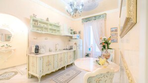 Una cucina in stile vintage con lavello, fornello e forno a microonde. C'è un tavolo da pranzo con sedie e un vaso di fiori.