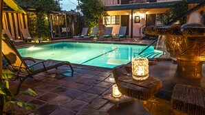 A swimming pool with lounge chairs and a stone fountain. - Hotel California - A Town & Desert Boutique Hotel (Palm Springs)