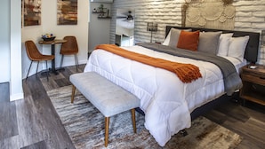 A modern bedroom with a large bed, a bench, a desk, and two chairs. - Hotel California - A Town & Desert Boutique Hotel (Palm Springs)