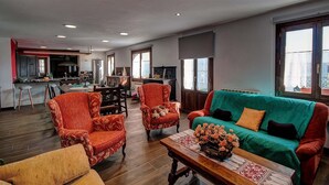 A spacious living room with a sofa, armchairs, and a coffee table. There is a kitchen in the background with modern appliances. - RURAL HOUSE IN SIERRA DE ARALAR, 4O KM FROM SAN SEBASTIAN-30 PAMPLONA 12 PEOPLE (Baráibar)