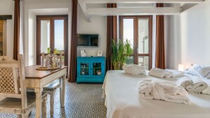 A hotel room with a bed, a desk with a chair, a television, and a window with curtains. - Studio gound floor with garden and Sea Views (Tarifa)