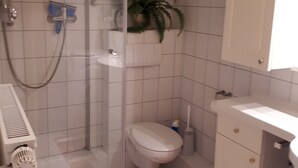 A bathroom with a shower, toilet, sink, and a potted plant. - Idyllic and quietly located vacation apartment in the university town of Idstein🌳 (Idstein)