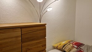 A bedroom with a wooden dresser, a bed with a pillow, and a unique ceiling light fixture. - Unwind, relax, recover ... - Indoor swimming pool (12x6m) u. Sauna in the house! (Unterkirnach)