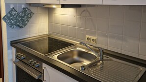 A kitchen with white cabinets, a stainless steel sink, and a built-in oven. - Unwind, relax, recover ... - Indoor swimming pool (12x6m) u. Sauna in the house! (Unterkirnach)