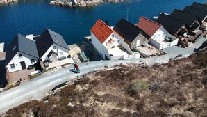 A coastal village with houses directly adjacent to a body of water, featuring a narrow road and rocky terrain. - Fishing, 2 top boats, swimming, SUP, workation, relaxing, everything is possible (Urangsvåg)