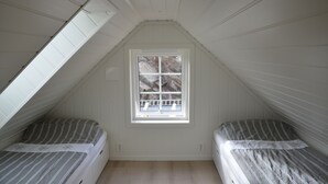A small attic bedroom with two beds, a window, and sloped ceilings. - Fishing, swimming, hiking, relaxing, workation, and more (boats optional) (Urangsvåg)