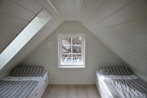 A small attic bedroom with two beds, a window, and sloped ceilings. - Fishing, swimming, hiking, relaxing, workation, and more (boats optional) (Urangsvåg)