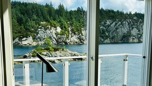 A room with a desk and chair facing a large window overlooking a rocky coastline and a body of water. - Fishing, 2 top boats, swimming, SUP, workation, relaxing, everything is possible (Urangsvåg)