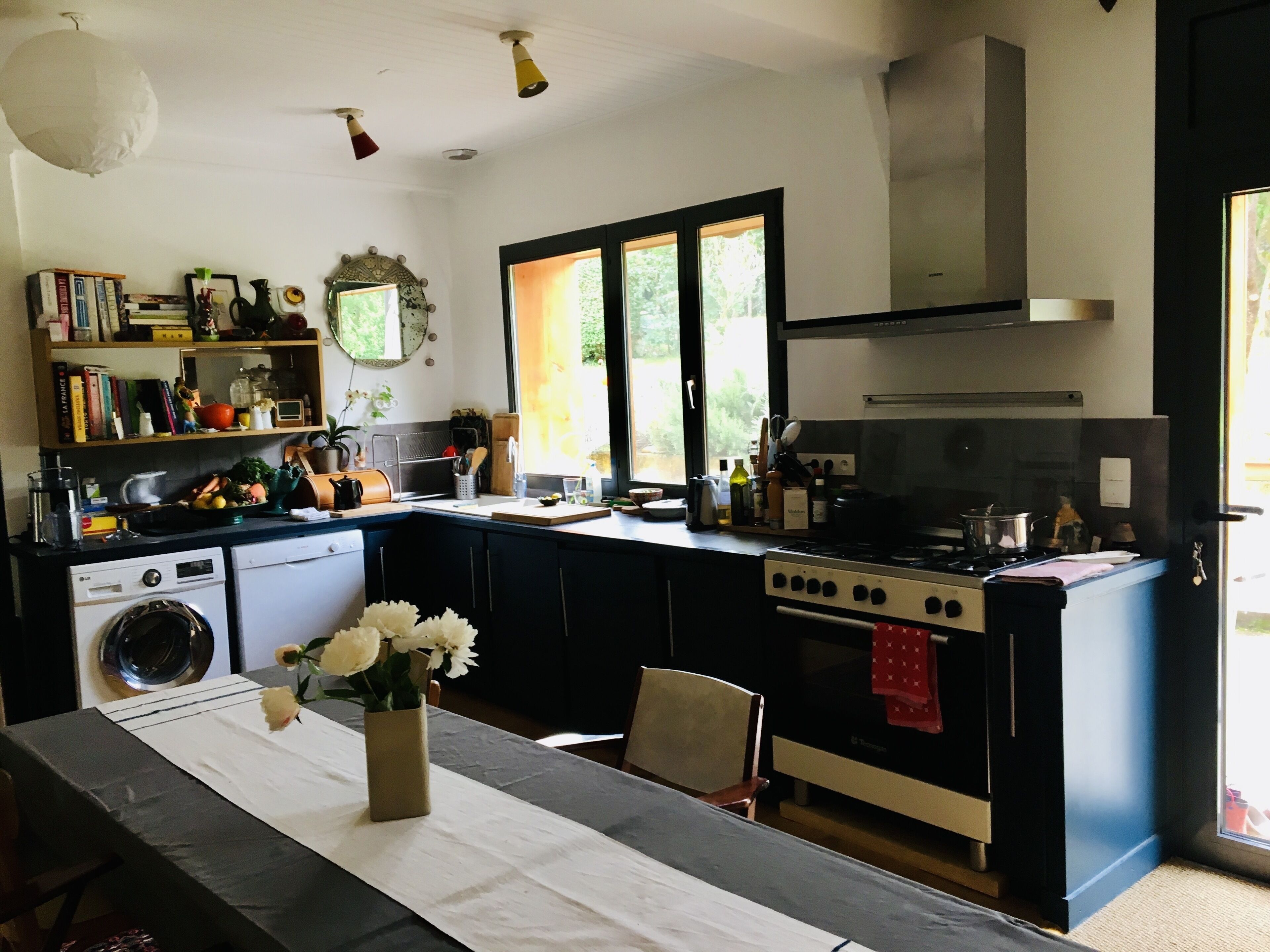 A kitchen with a dining table, a stove, and a washing machine.