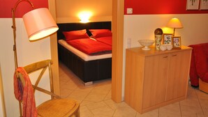 Une chambre à coucher avec un lit, des lampes de chevet, une table de chevet en bois et une chaise.