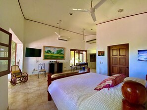 Relax in comfort with a large bed, desk, and ceiling fan, perfect for a restful stay.