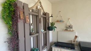 Ein Zimmer mit einer rustikalen Holzhockerreih und einem kleinen Grill, dekoriert mit Zimmerpflanzen.