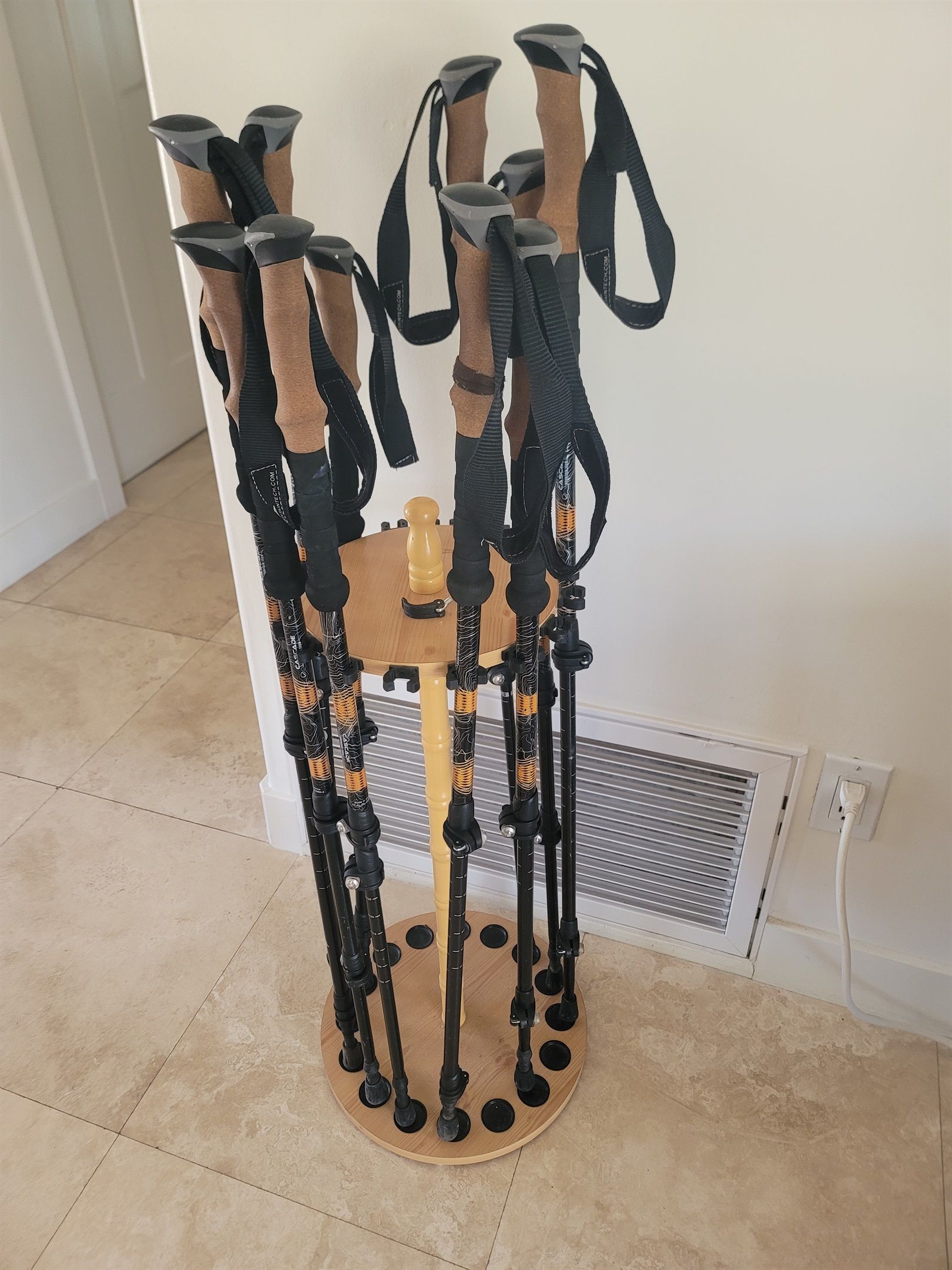Un support en bois doté de plusieurs sangles noires et d’un bouton central en bois.
