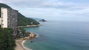 A coastal hotel with a beach view, a large building with multiple balconies, and a rocky shoreline. - Beautiful Condo in Playas Gemelas, Puerto Vallarta (Puerto Vallarta)