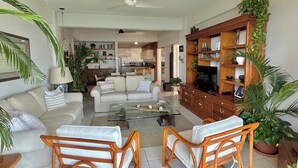 A spacious living room with a sofa set, a coffee table, and a TV stand with shelves. - Beautiful Condo in Playas Gemelas, Puerto Vallarta (Puerto Vallarta)