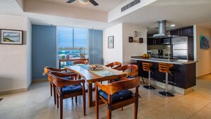 A modern kitchen with a built-in island, a dining area with a view, and a ceiling fan. - OCEANFRONT CONDO IN TROPICAL PARADISE AWAITS YOU AT THE GRAND VENETIAN! (Las Glorias)