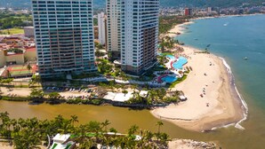A coastal resort with high-rise buildings, a beach, and a swimming pool. - OCEANFRONT CONDO IN TROPICAL PARADISE AWAITS YOU AT THE GRAND VENETIAN! (Las Glorias)