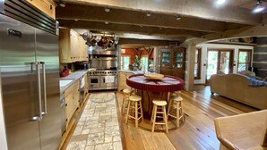 Una cocina amplia con una isla central, piso de madera y electrodomésticos modernos.
