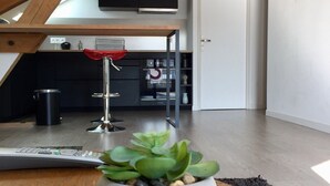 A modern kitchen with dark cabinets, a red towel, and a hanging rack.