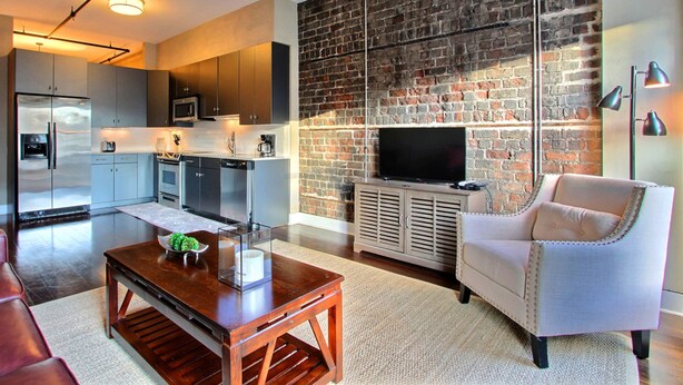 Un salon moderne avec une cheminée, un téléviseur et un coin repas.