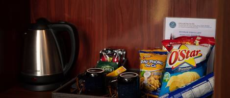 A tray with snacks, a kettle, and a price list.