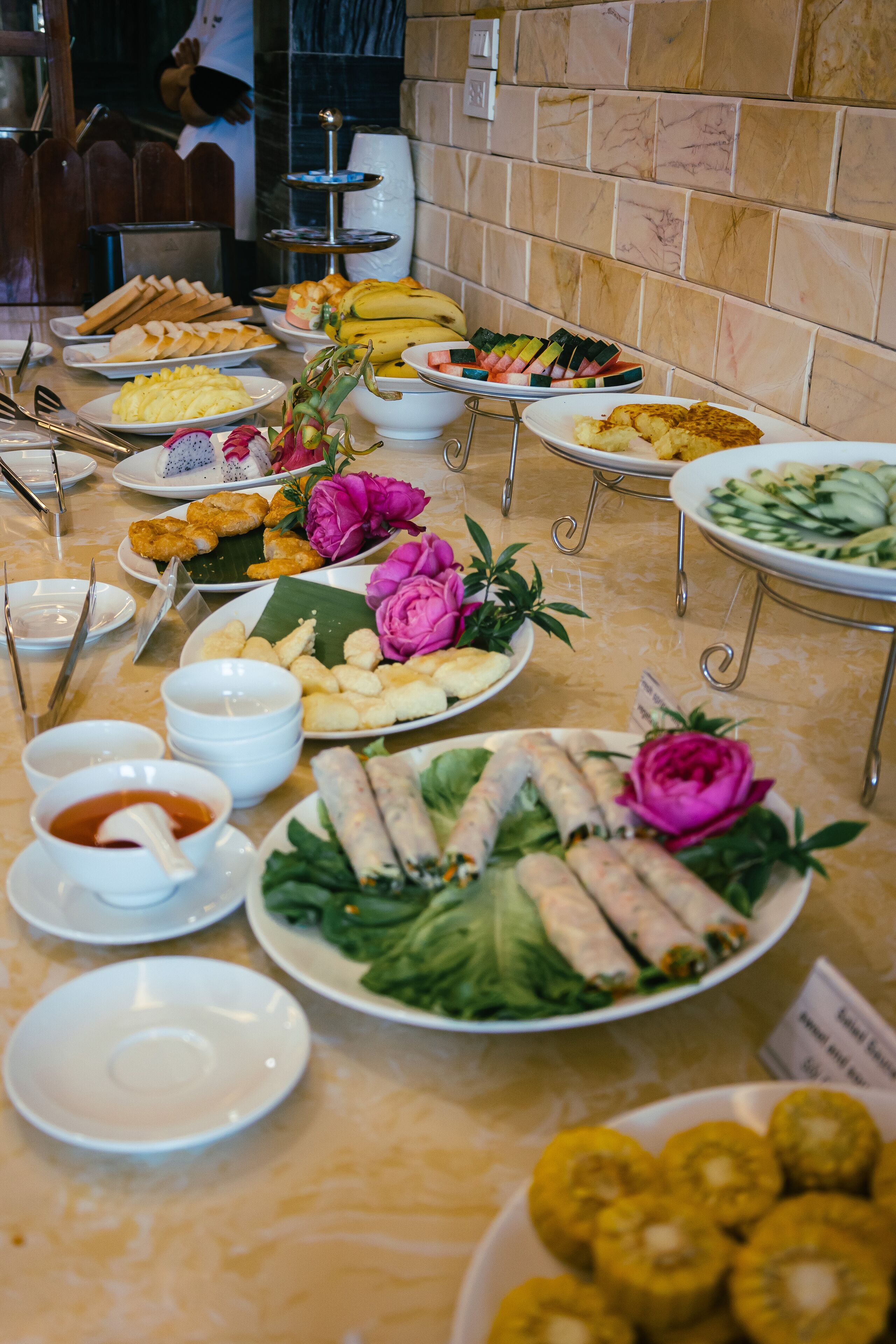 A buffet table with various dishes and a sign indicating the type of cuisine.