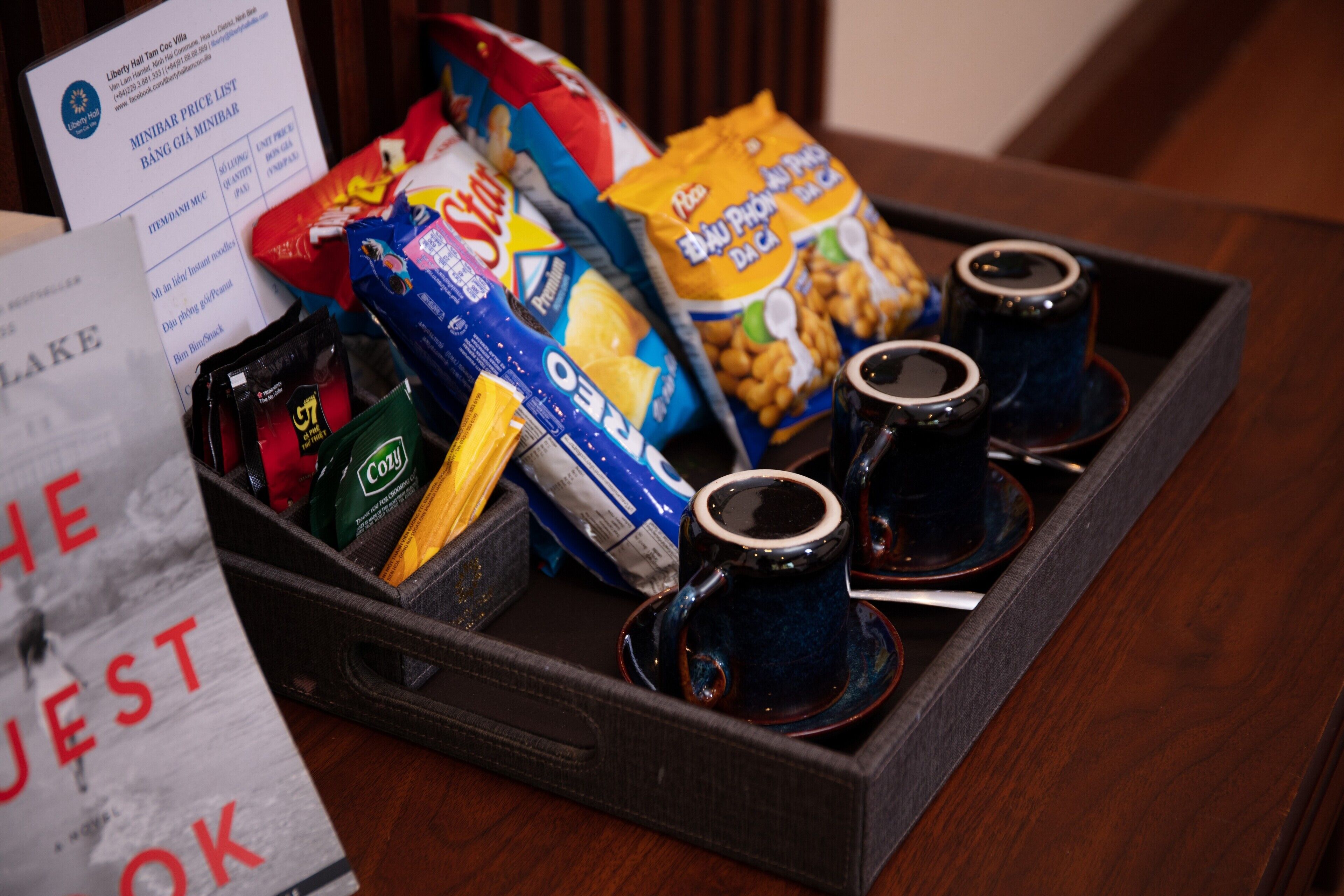 Een dienblad met snacks, koffiekopjes en een menukaart.