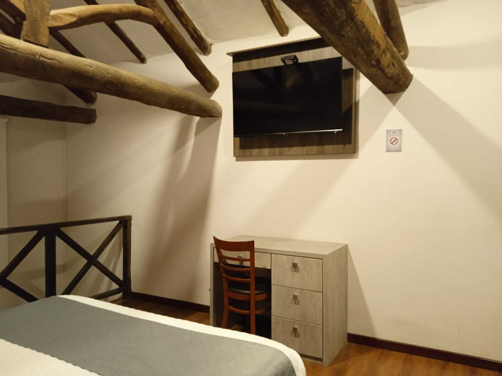 Un dormitorio con cama, escritorio y silla.