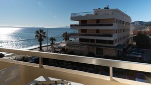 A multi-story hotel with balconies overlooking a beach.