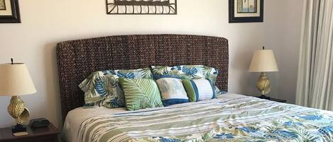 A neatly made bed with a floral bedspread, two bedside tables with lamps, and framed artwork on the walls.
