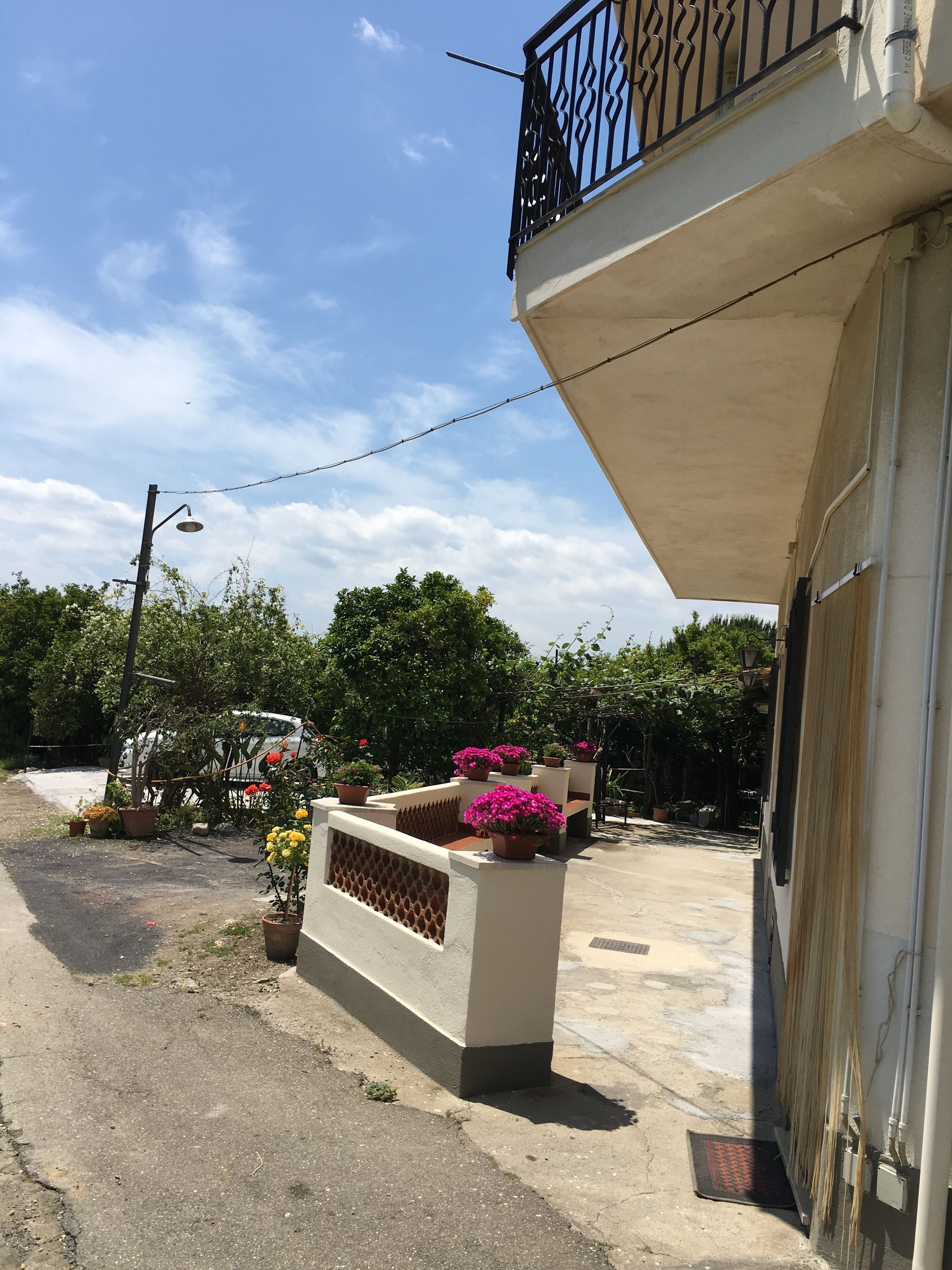 Un immeuble d’habitation doté d’un balcon, de plantes en pot et surplombant un ciel dégagé.