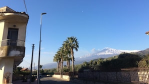 A street with a building, a street lamp, and a fence. - Al Chiaro di Luna (Taormina)