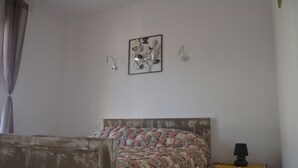 A bedroom with a bed, a nightstand, a lamp, and wall art. - Gîte with barbecue and enclosed terrace close to shops and rivers (Lagorce)