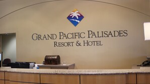 A reception desk at Grand Pacific Palisades Resort & Hotel with a logo above the name, a wooden counter, and a telephone on the right. - Grand Pacific Palisades Resort - 2 Bedroom/2 Bath - LAST MINUTE SPECIAL!!! (Carlsbad)