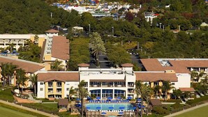 A resort with a swimming pool, multiple buildings, and a theme park in the background. - Grand Pacific Palisades Resort - 2 Bedroom/2 Bath - LAST MINUTE SPECIAL!!! (Carlsbad)