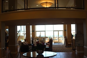 A lobby with a view of the city, a staircase, and a buffet sign.