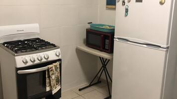 Une cuisine équipée d’une cuisinière, d’un four, d’un four à micro-ondes et d’un réfrigérateur.