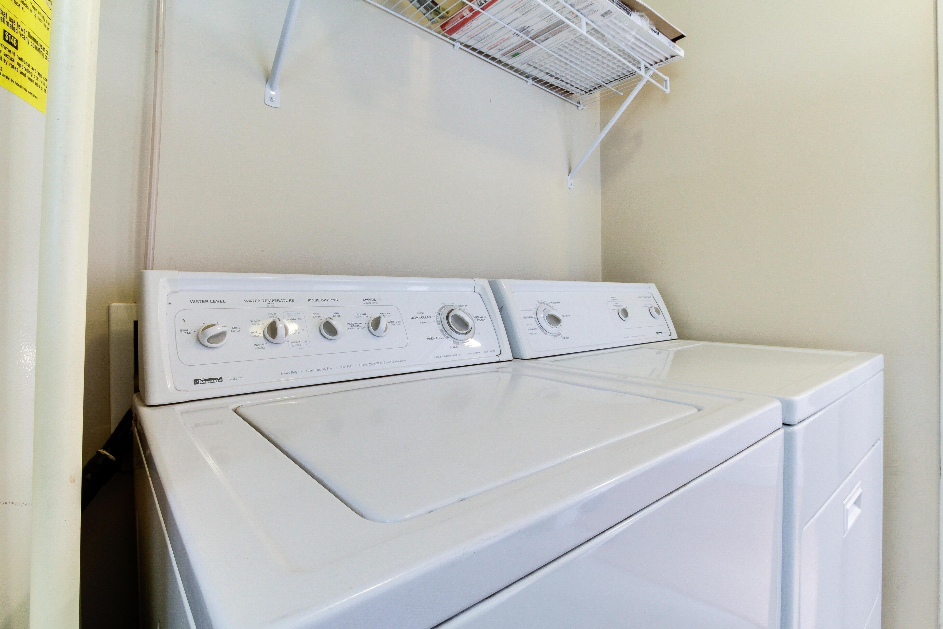 A front-loading white washer and dryer unit with control knobs and a water level indicator.