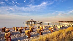 A beach with beach huts and a pier extending into the water. - Exclusive apartment 4 for 2-4 persons near Timmendorfer Strand - Ferienhof am (Ratekau)