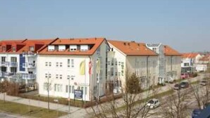 A row of modern buildings with red roofs, likely residential or office buildings. - Double room - Hotel Poinger Hof (Poing)