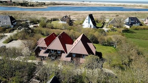A coastal village with traditional houses, a sandy beach, and a calm sea. - Luna IV - Luna Apartment 30 (Sankt Peter-Ording)