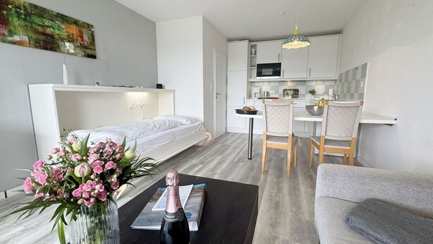 Un apartamento moderno con cama, comedor y cocina.