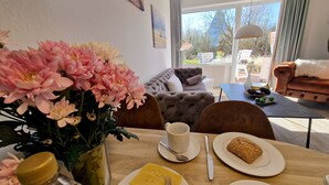 Zona pranzo con tavolo apparecchiato per due, con un piatto di formaggio e una pagnotta.