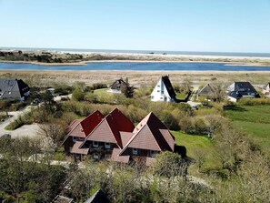 A coastal village with traditional houses, a sandy beach, and a calm sea. - Luna IV - Luna apartment 28 (Sankt Peter-Ording)