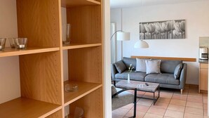 Un soggiorno moderno con un divano grigio, un tavolino da caffè e una libreria.
