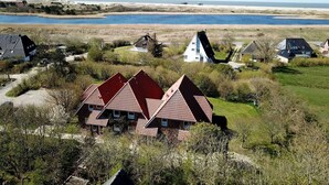 Ein Küstendorf mit traditionellen Häusern, einem Sandstrand und einer ruhigen See.